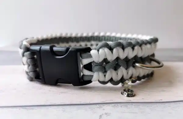 A handmade dog collar braided with grey & white paracord 550 in the wide solomon bar knot style